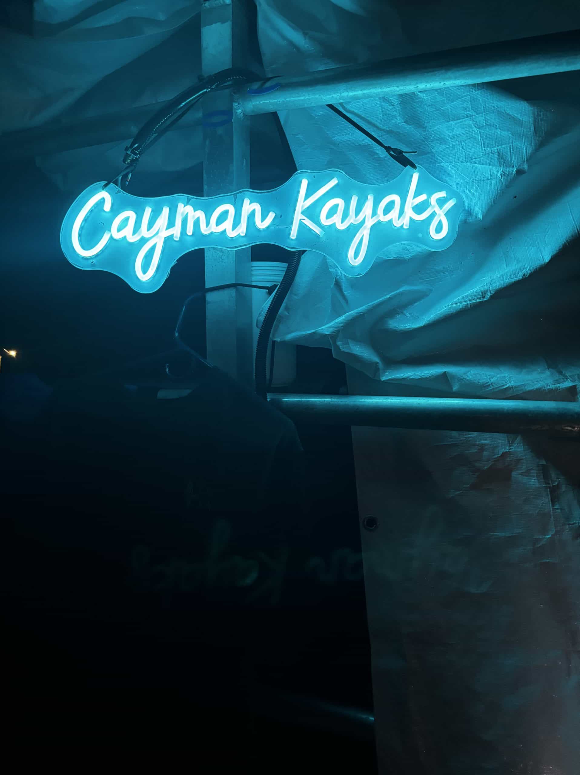 Neon blue sign reading 'Cayman Kayaks'