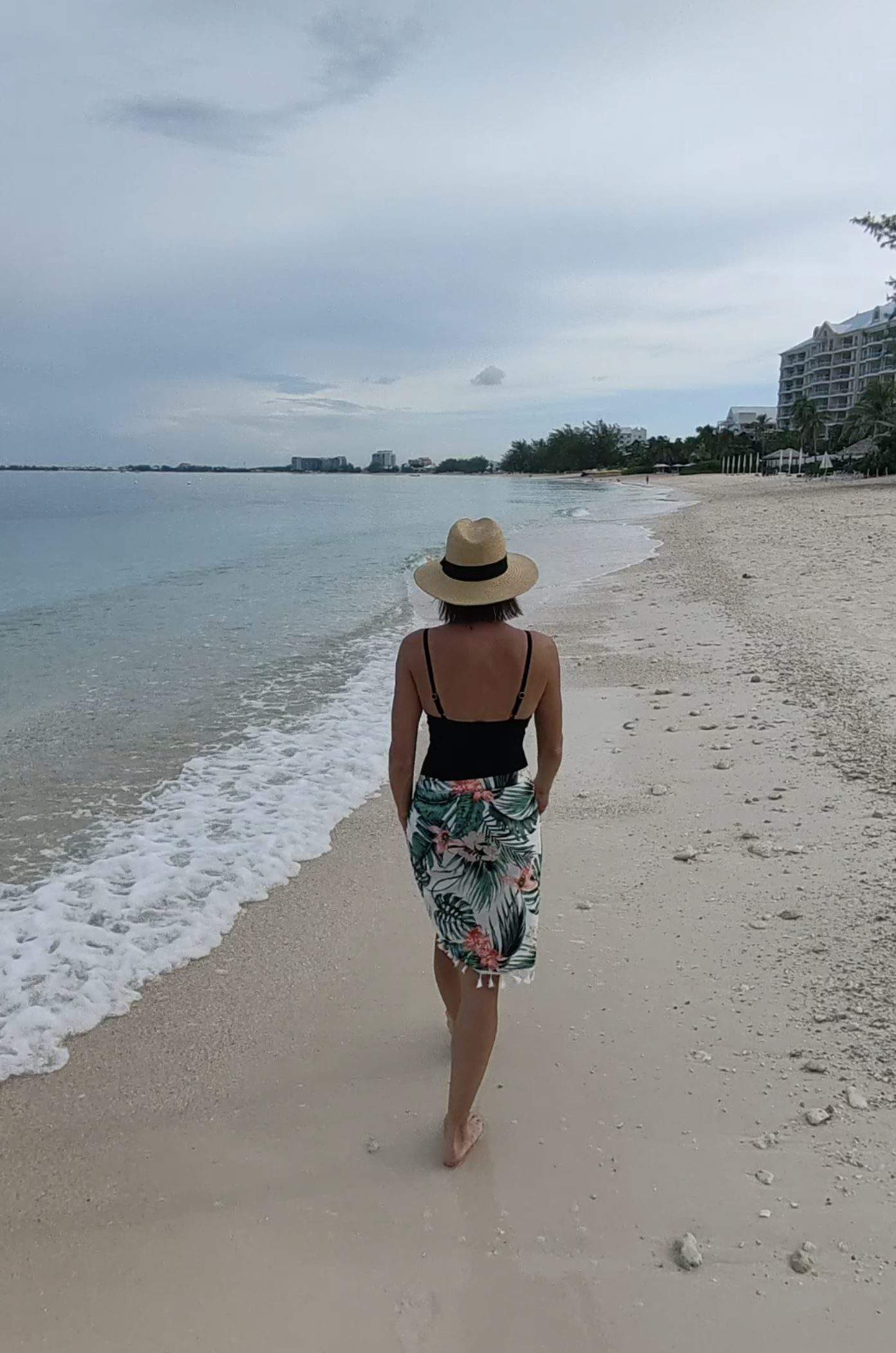A woman walking alone on Seven Mile Beach in Grand Cayman