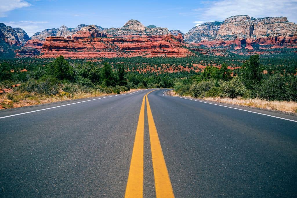 a winding road leading to the red rocks in Sedona