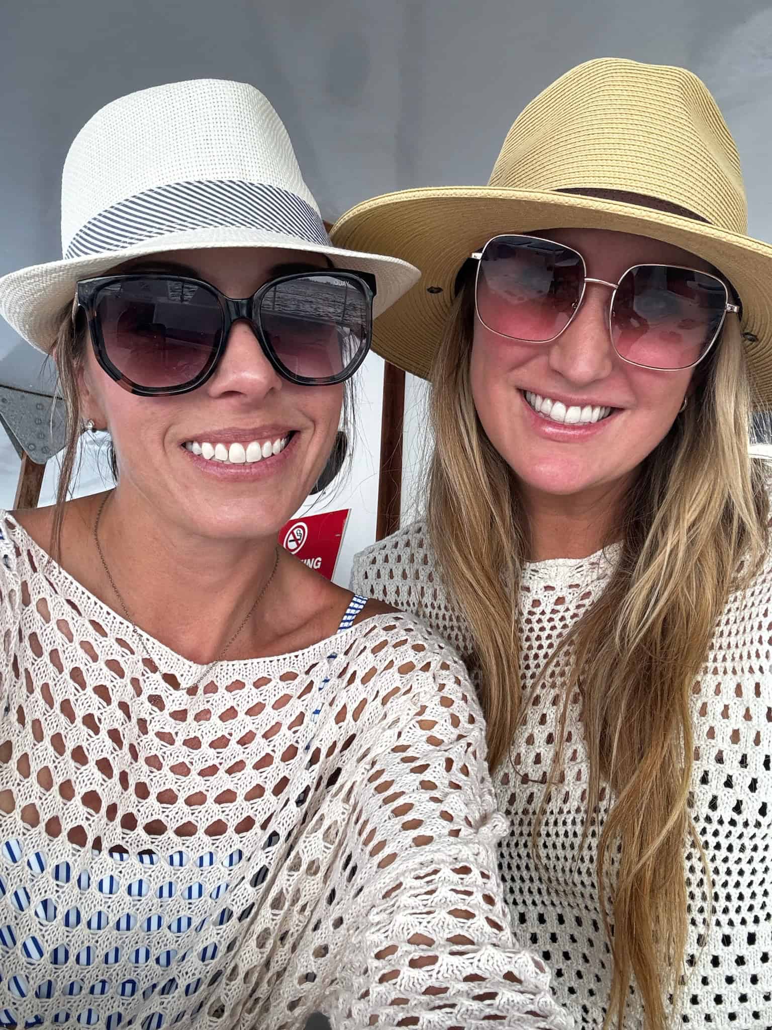 Two women with Panama hats and beach coverups.