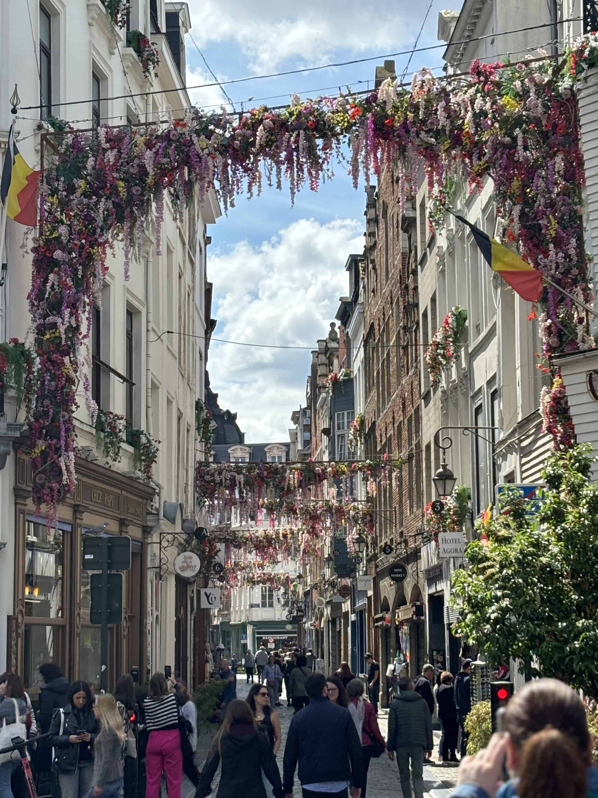 A street lined with people and flowers in Brussels.