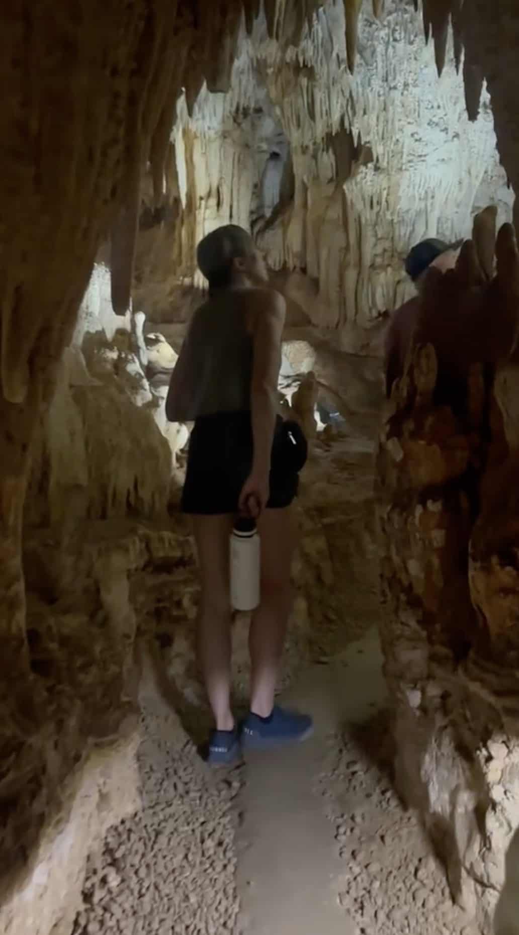 Woman walking through a cave at the Cayman Islands' Crystal Caves