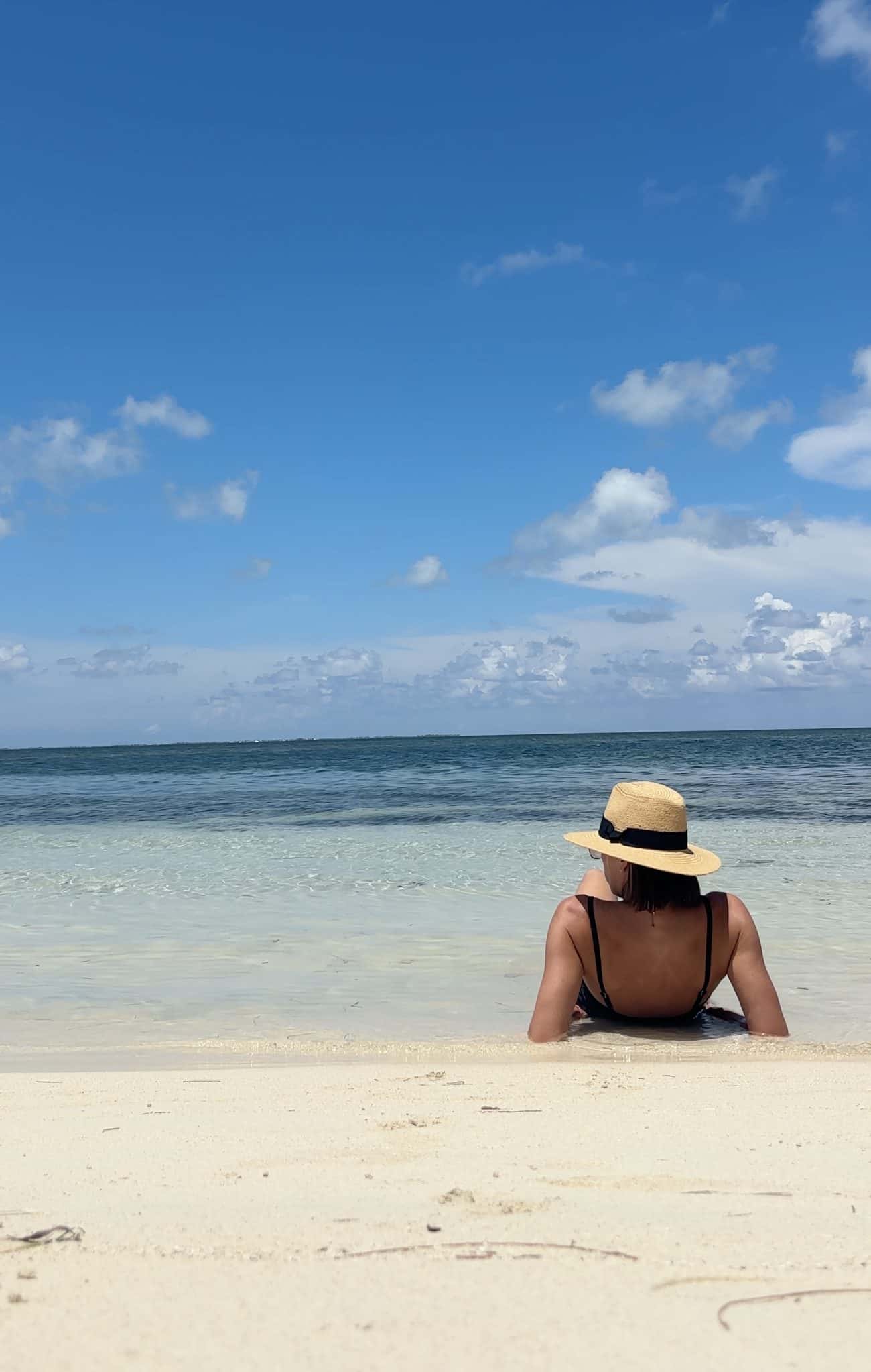 A woman lying on the beach at Starfish Point, Grand Cayman