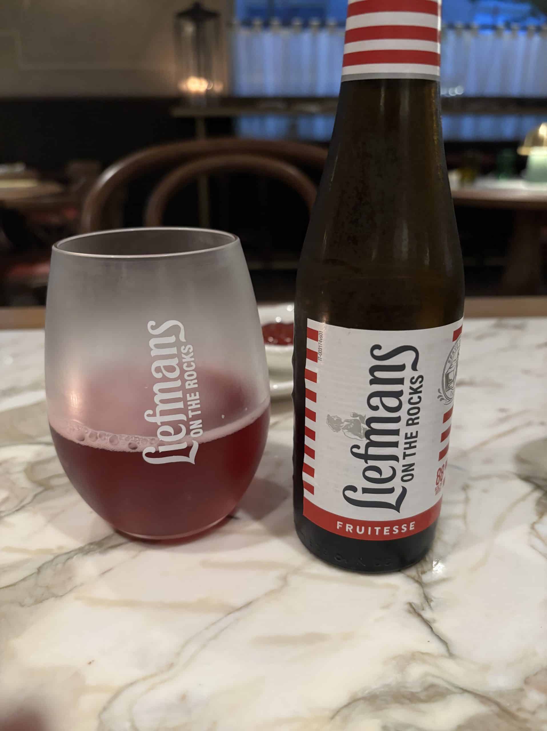 Liefman's Belgian beer poured into a glass on the table with the bottle next to it.