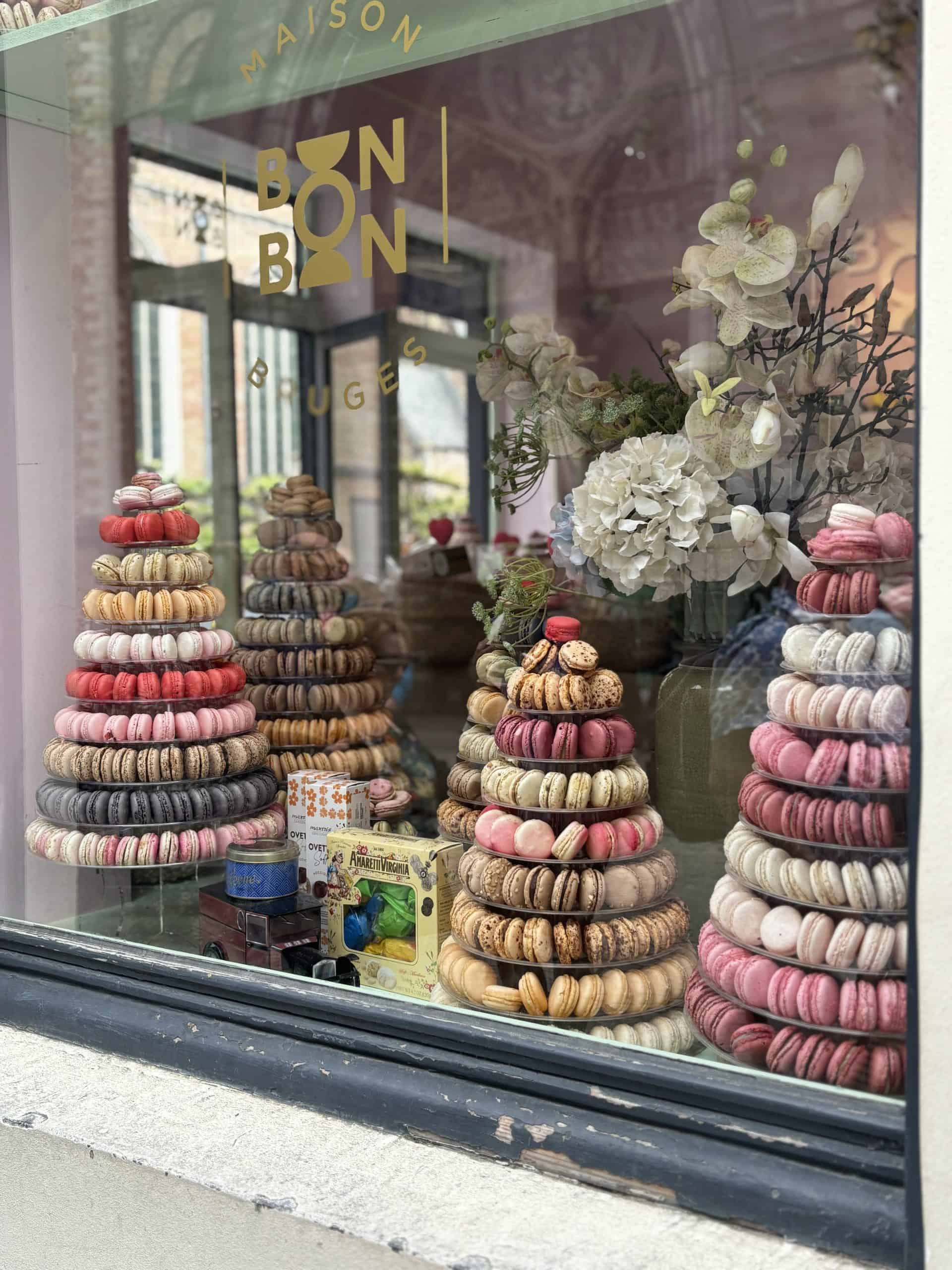 Two towers of multi-colored macaroons in a store-front window.