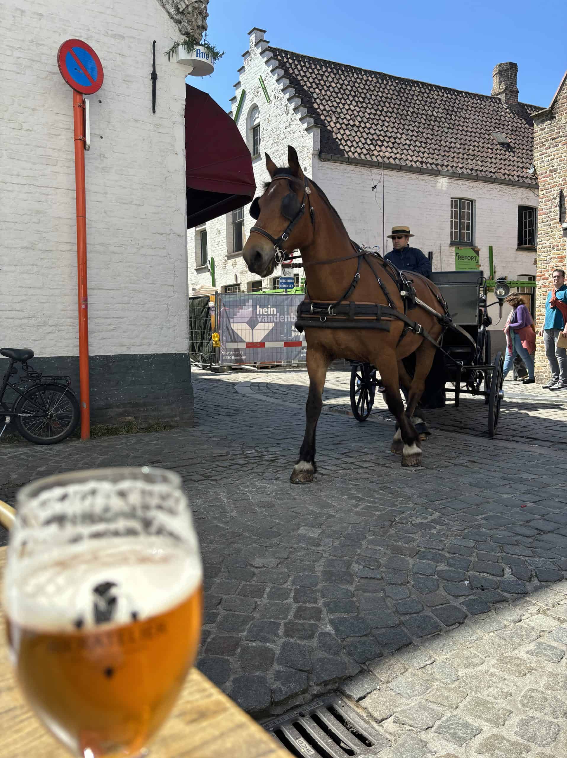 A horse-drawn carriage rounding a corner in Bruges, Belgium.