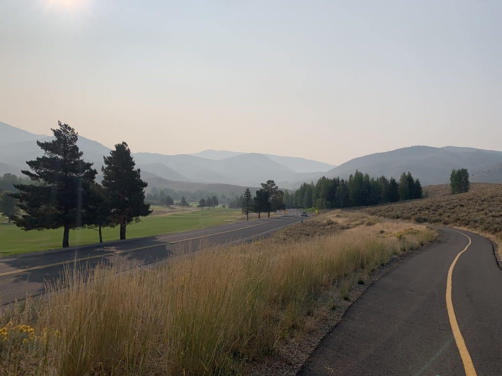A windy bike trail next to a road amongst rolling hills